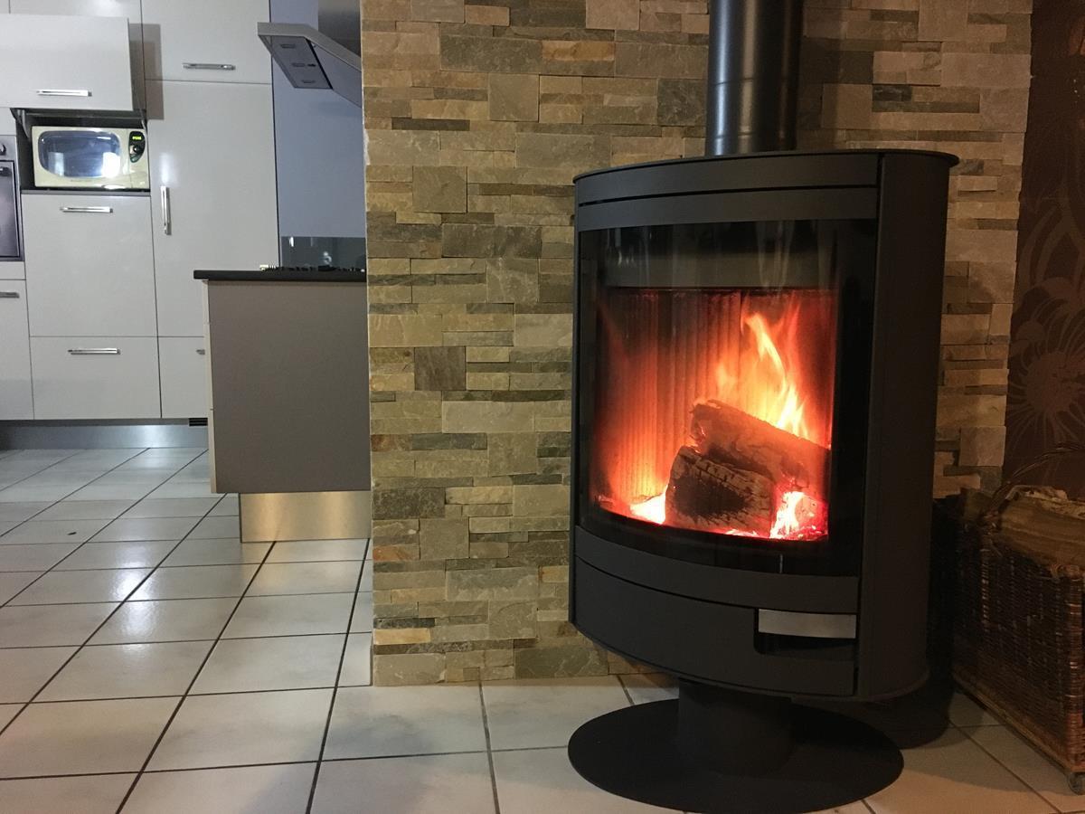 Poêle à bois Stromboli N, best-seller de ROMOTOP depuis plus de 10 ans, pivotant à 360°, offrant une vue imprenable sur les flammes.